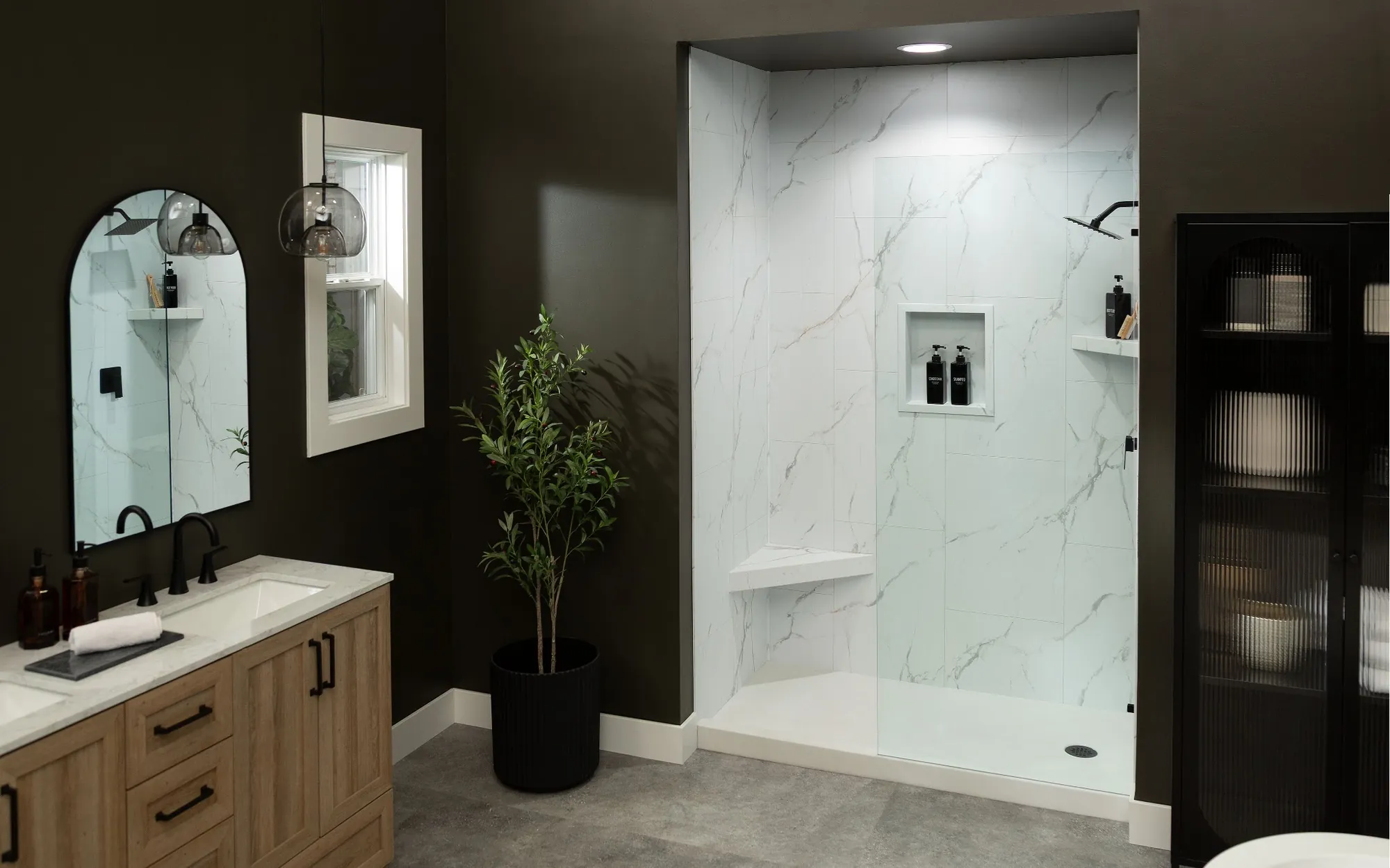 Remodeled bathroom with a marble-look walk-in shower, oak vanity and matte black fixtures