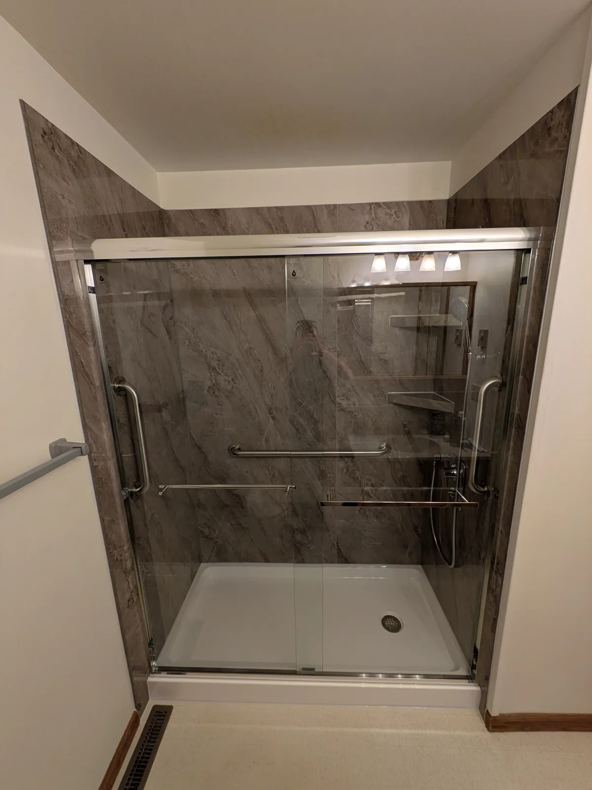 Inside the finished shower, grab bars and corner shelves