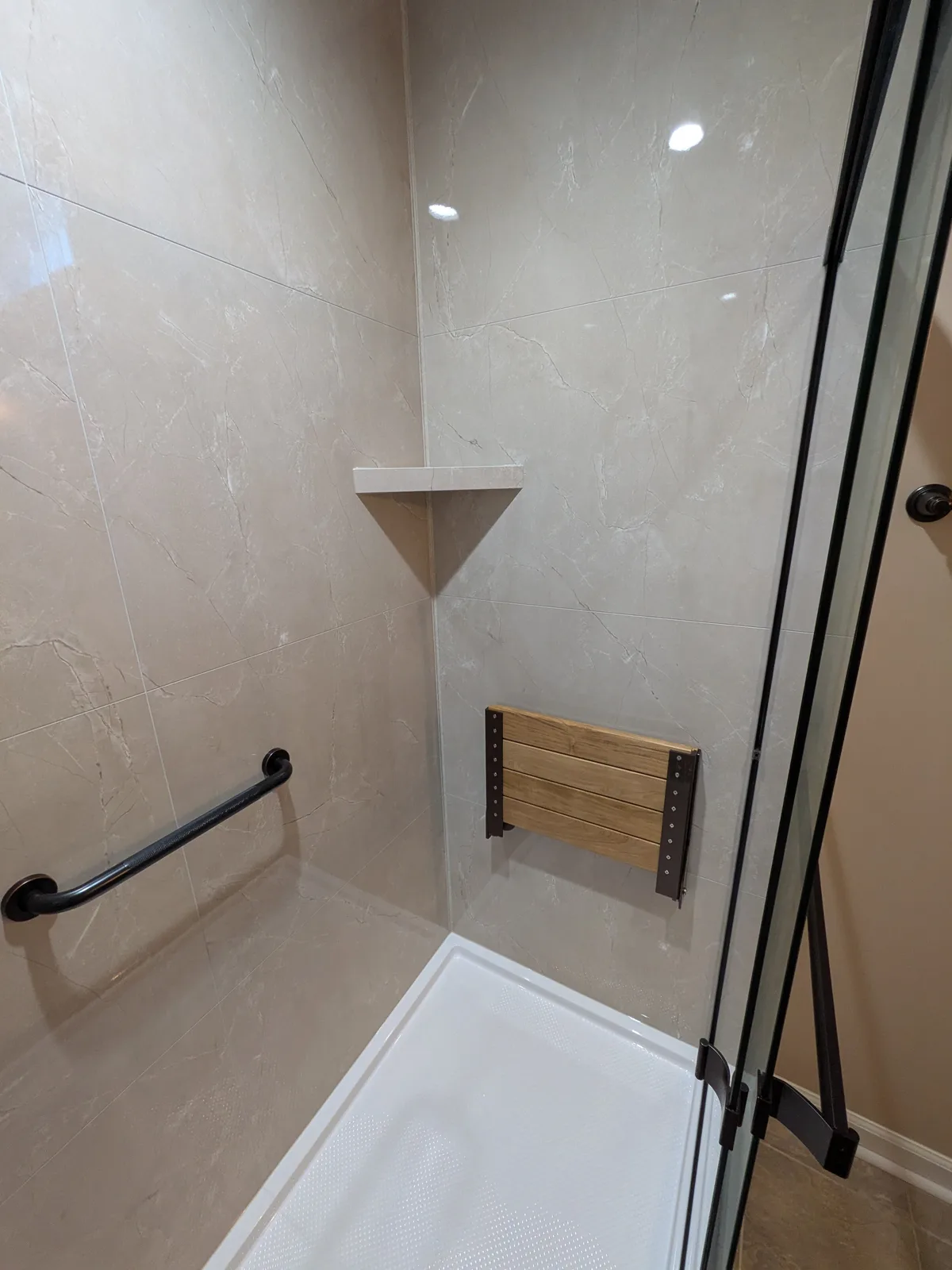 Bronze sliding doors and marble-look walls, another angle