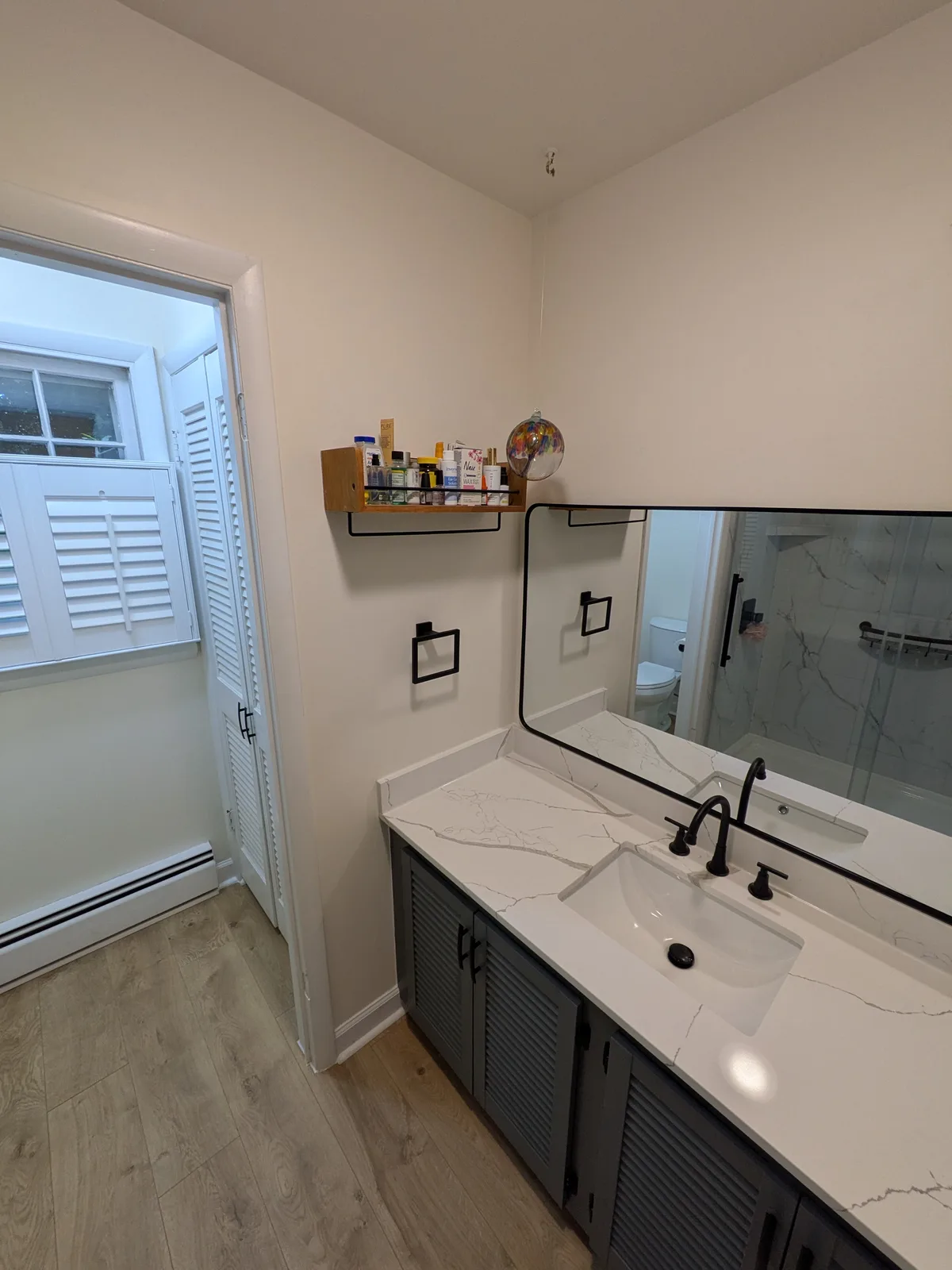 New bathroom vanity with a marble-look quartz top and matte black fixtures
