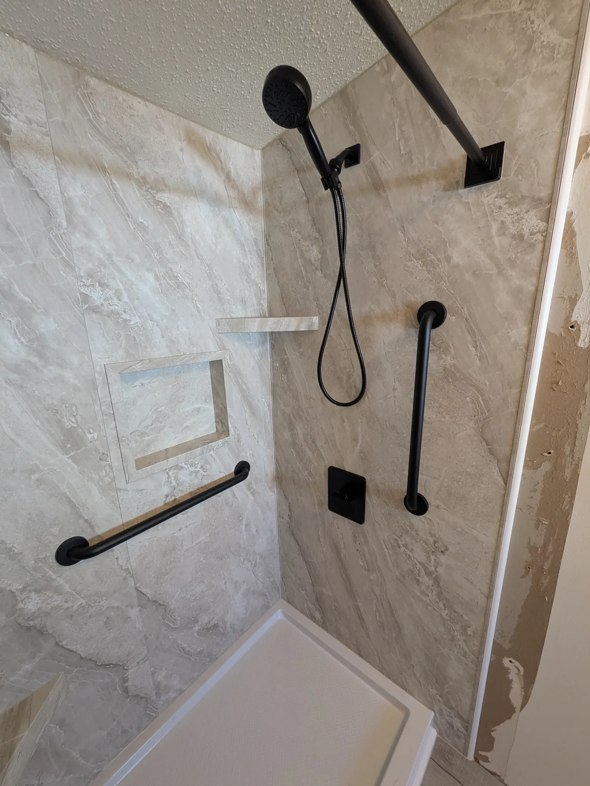 Close view of the new shower walls, niche and fixtures