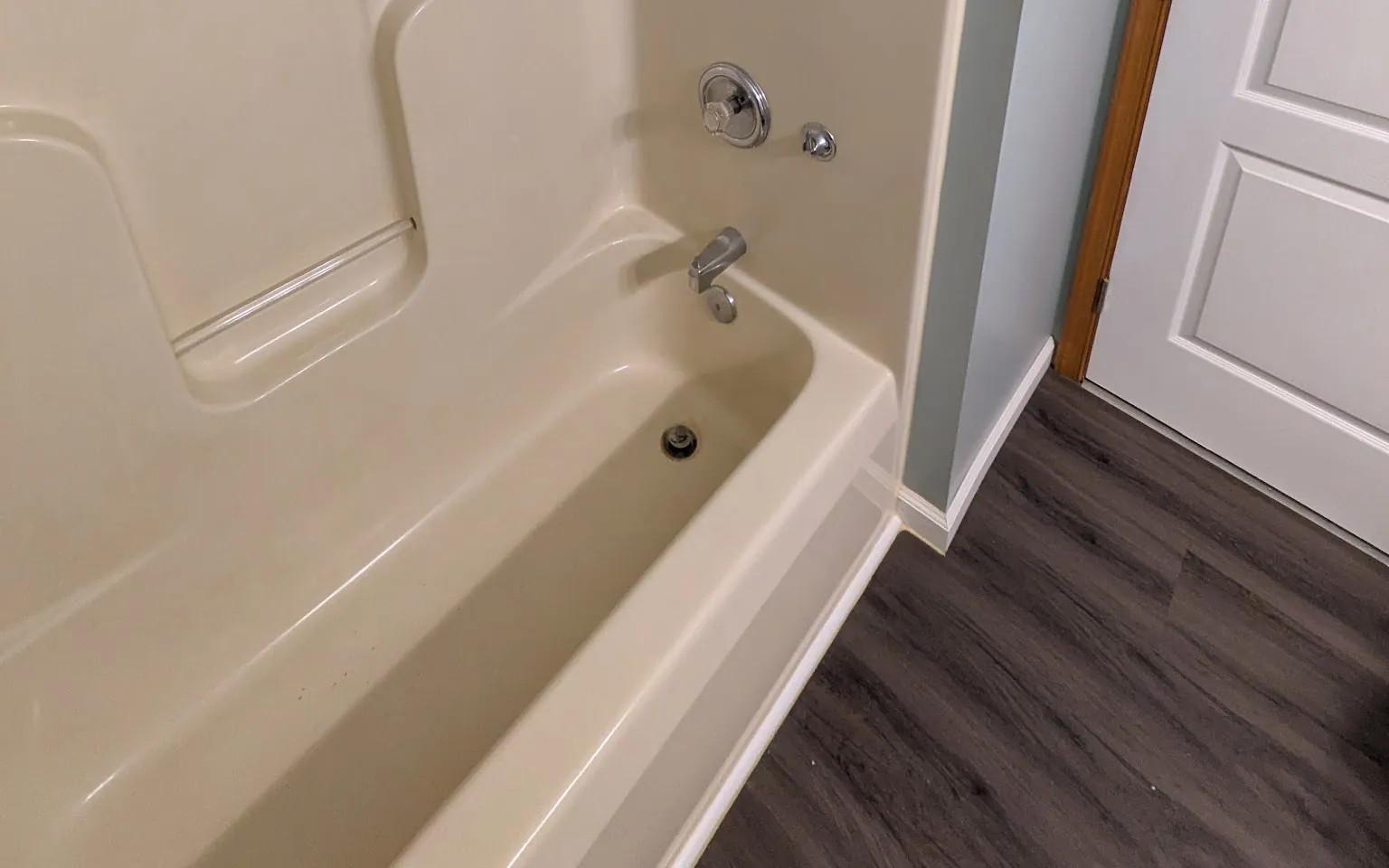 Refreshed family bathroom in soft sage with a tiled tub surround